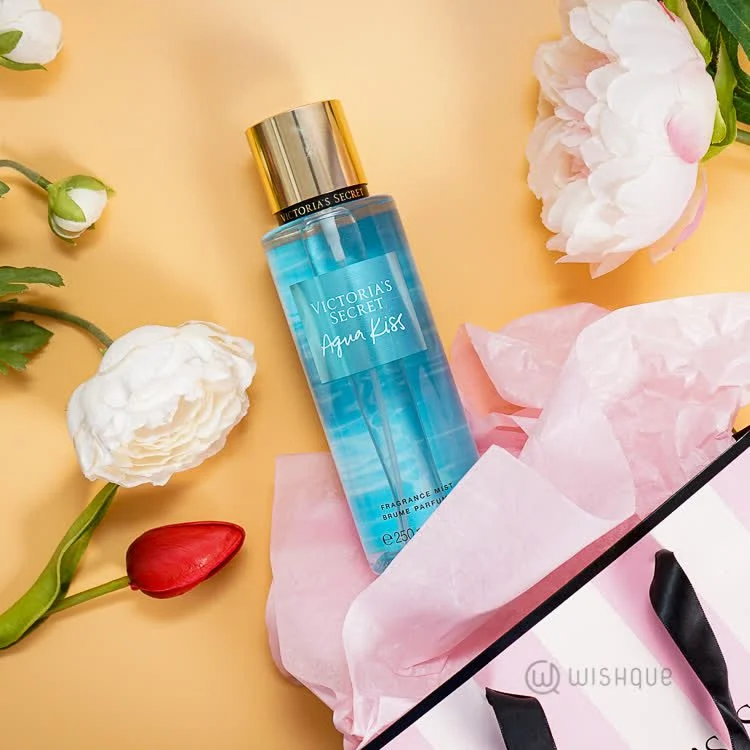 عطر آکواکیس روی زمین کنار گل